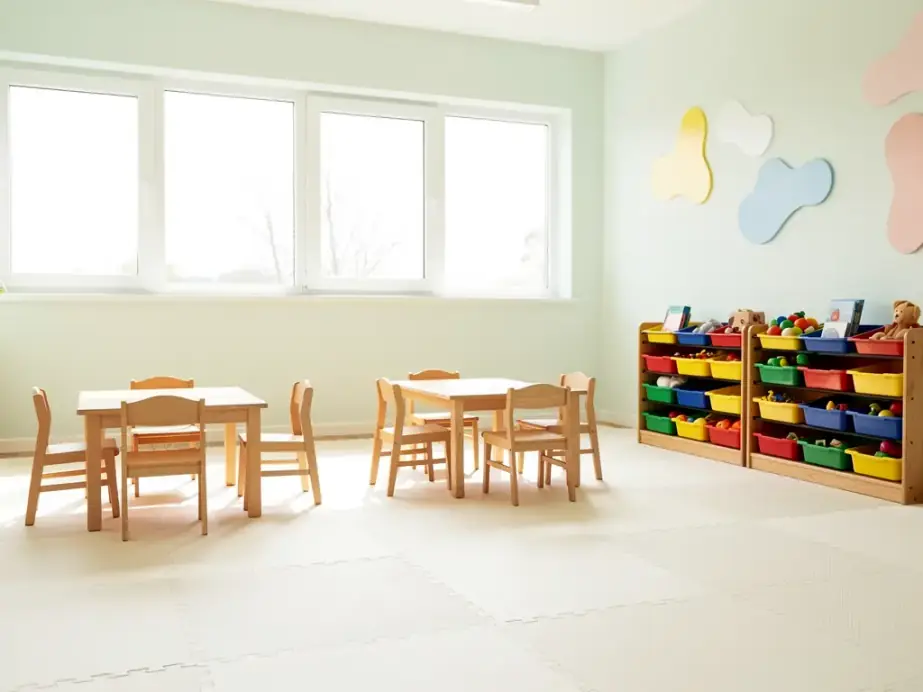Bright day care classroom with small tables and chairs